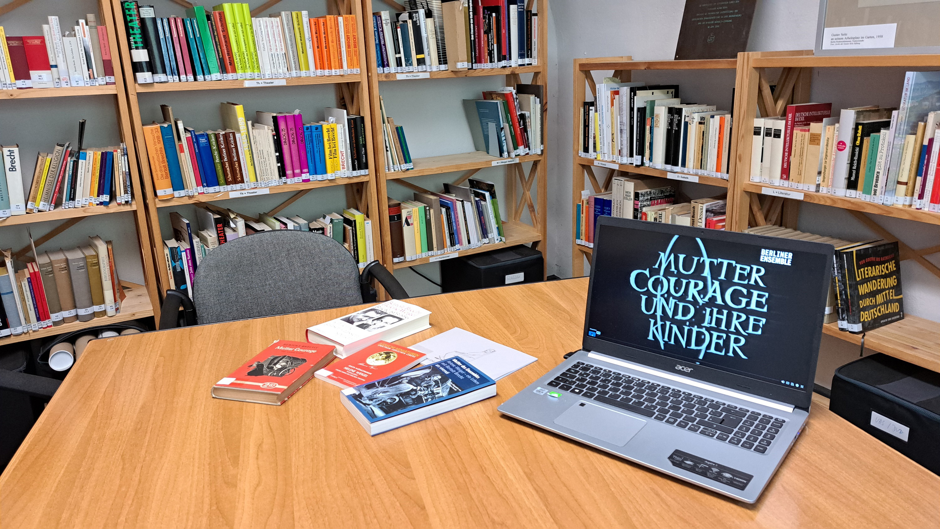 Innenansicht der Bibliothek im Brecht-Weigel-Haus zeigt Holzregalen gefüllt mit Büchern und einem Lesetisch